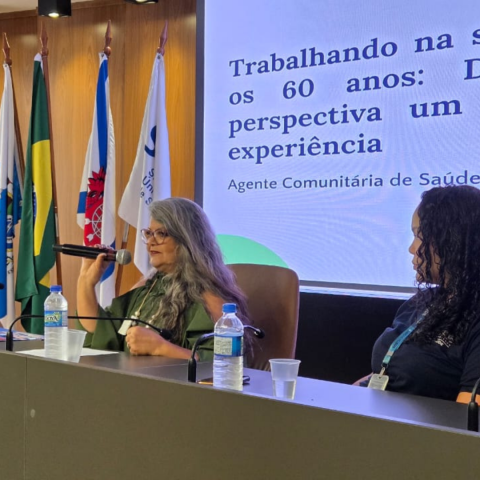 Palestrante sentada a mesa do evento