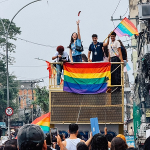 Residentes na parte de cima do trio elétrico jogando preservativos para o público 