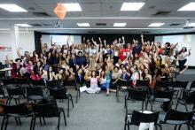 Palestrantes e convidados ao palco comemorando evento